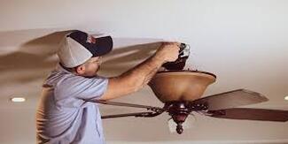 Electricians installing ceiling fan
